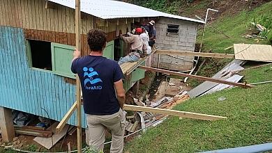 Man Looking at Workers Fix House