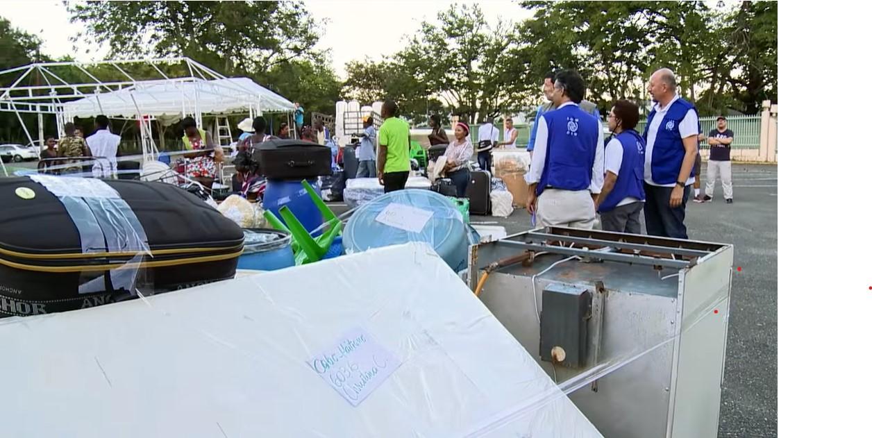 Migrants with IOM Staff