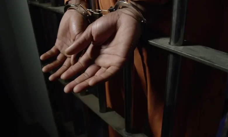 Man in Handcuffs Behind Bars