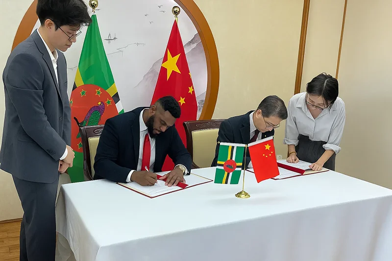 Hon. Cassanni Laville and Chinese Ambassador to Dominica Chu Maoming sign documents at the official signing ceremony