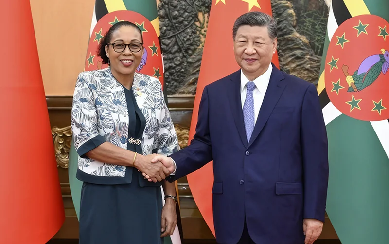 Dominica’s President Sylvanie Burton, shaking hands with Chinese President Xi Jinping. While the flags of Both Countries are in the background