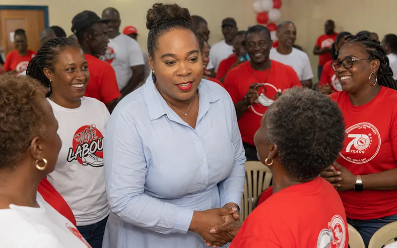 Ashma McDougall interacts warmly with DLP supporters at a Goodwill Parish Hall campaign launch, with some supporters wearing red or white T-shirts
