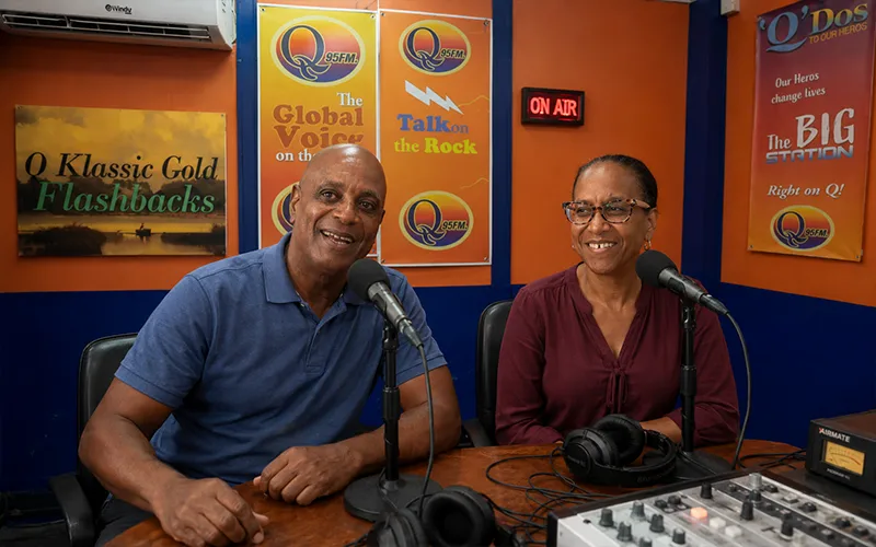 Juliette Shillingford and Daniel “Danny” Lugay dressed in neat casual clothing participate in a live radio discussion inside the Q95FM studio.