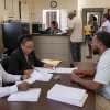 Election officers in Roseau reviewing nomination papers with a prospective candidate for the Roseau City Council By-Election.