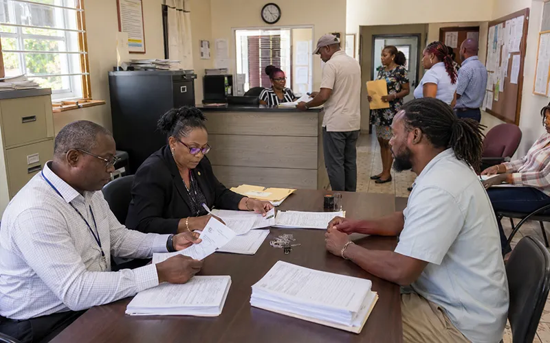 Election officers in Roseau reviewing nomination papers with a prospective candidate for the Roseau City Council By-Election.
