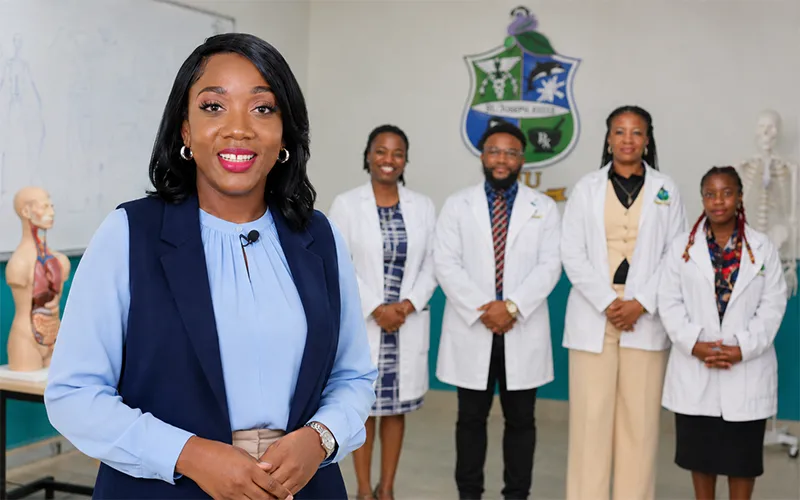 A St. Joseph University representative discusses reduced tuition for Dominican students as four medical trainees stand behind her.